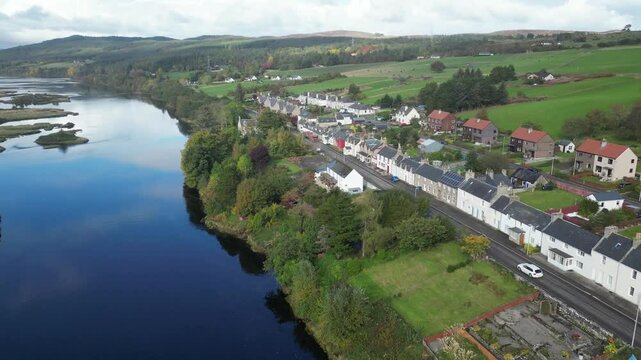 tracking suv navigates through charming bonar bridge village backdrop serene kyle sutherland enhancing aerial shot car river lake drone scenic nature highlands adventure travel 