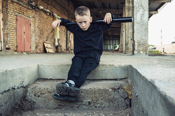 Little boy in black with a baseball bat.