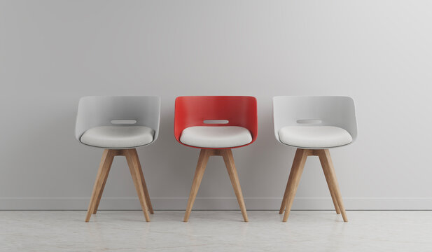 Two white chairs and red on white wall background  Row of modle chairs with one of different colour. Job opportunity, recruitment, hiring concept.
