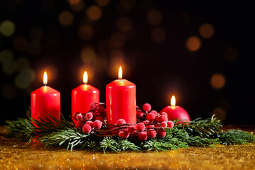 Four red Christmas candles on a dark background