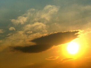 Sky with sun, clouds and orange, yellow and blue colors during sunrise - natural background. Topics: sun energy, weather, meteorology, atmosphere, air space, dawn, morning
