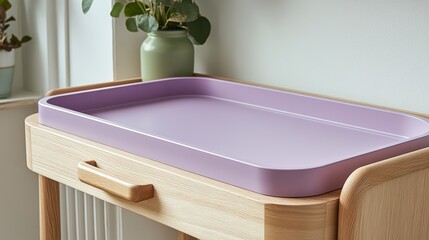 Pastel colored changing table with lavender and pink drawers in a warm nursery setting