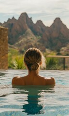 Fototapeta premium Woman in a pool with mountain view.