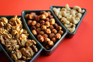 different types of nuts, Various snacks for the New Year table in a plate in the shape of a Christmas tree.