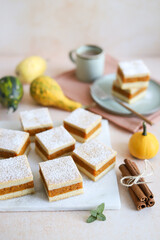 Pumpkin pie. Autumn dessert. Cinnamon sticks. Light orange background. Green plate and cup of coffee. 