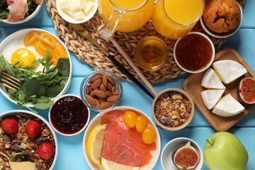 Different tasty food served for brunch on light blue wooden table, flat lay