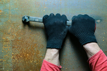 Hands unscrew the nut with a wrench.