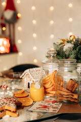 Gingerbread house with glaze, table decoration for Christmas with homemade baking. Christmas tree, citrus, garland basket