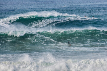 Fototapeta premium Big waves at Nazarè beach in Portugal, photographs of surfers having fun in the Atlantic Ocean