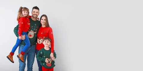 Happy family in Christmas clothes on light background with space for text