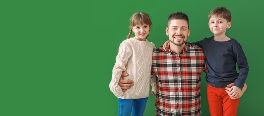 Obraz premium Happy family in winter clothes on green background with space for text