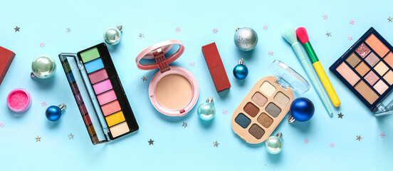 Fototapeta premium Makeup products and Christmas decor on blue background