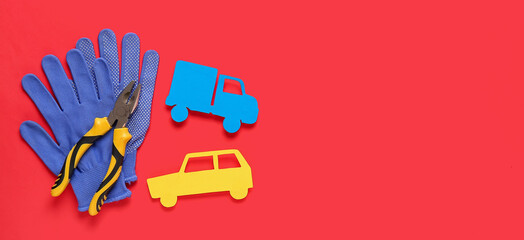 Pliers, gloves and toy car on red background. Mechanic concept