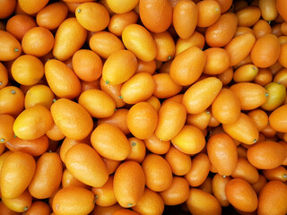 Lot fresh kumquats fruits background.