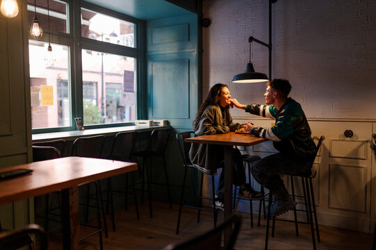 young couple in an affectionate and complicit attitude while enjoying a meal together during a romantic date in a restaurant.