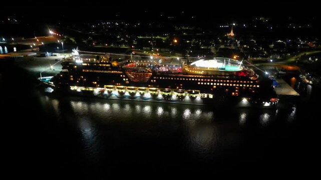 cruise ship docked moored port night vessel illuminated against dark waters invergordon outward aerial drone shot travel holiday adventure harbor scenic nature exploration journey 