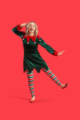 Happy young woman dressed as elf on red background