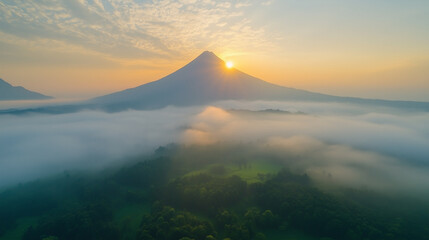 Golden sunrise over a serene mountain peak shrouded in mist, creating a tranquil atmosphere with soft light and peaceful scenery perfect for nature backgrounds or landscape designs