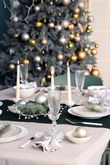 Beautiful table setting with burning candles and Christmas decorations in dining room