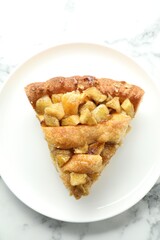 Slice of homemade apple pie on white marble table, top view