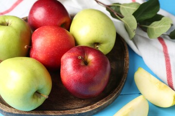 Fresh red and green apples on light blue wooden table, closeup