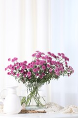 Beautiful pink flowers in vase on table indoors. Space for text