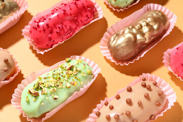 Composition with different glazed eclairs on color background