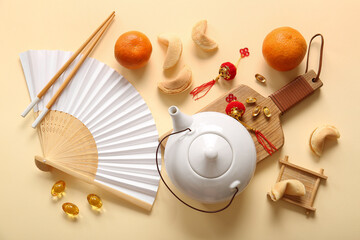 Teapot with Chinese symbols, mandarins and fortune cookies on beige background. New Year celebration