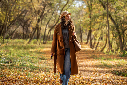 Beautiful middle aged woman walking in autumn park
