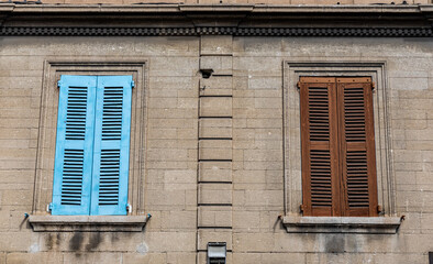 two colorful shutters on a historic house in the city of Avignon