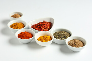 Bowls with fresh aromatic spices on light background