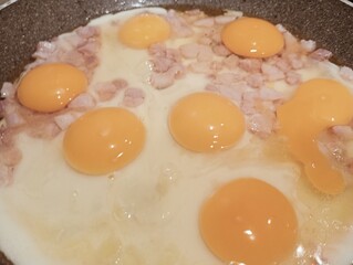 fried eggs with ham in a frying pan