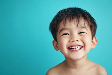 Asian child boy with almond-shaped eyes and light skin, laughing on a blue background 1