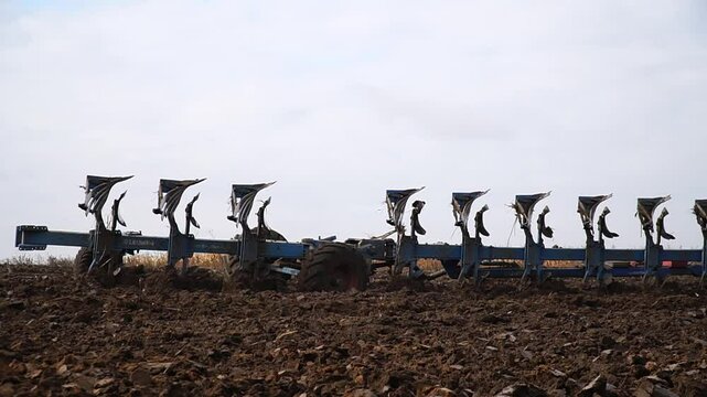 Reversible cultivator. Modern tractor with reversible plow plows the field. Soil cultivation with a cultivator. n