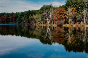 The clouds shade the overhead late-October morning sun from hitting all but a small portion of the opposite shoreline of Allen Lake within Hartman Creek State Park, Waupaca, Wisconsin.