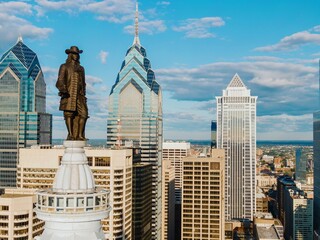 Statue of William Penn on top of  Philadelphia City Hall and the downtown city skyline of Philadelphia, Pennsylvania, United States.