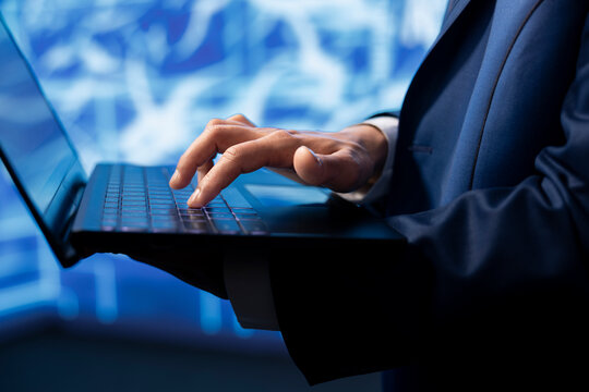 Data analyst using laptop to implement artificial intelligence parallel processing, breaking up complex computational tasks enabling AI systems to process more input data faster, close up shot