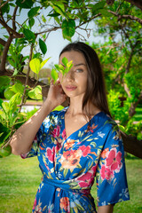 A woman peacefully walking between vibrant lemon trees, enjoying the fresh, natural surroundings, creating a calm and serene atmosphere in a garden.