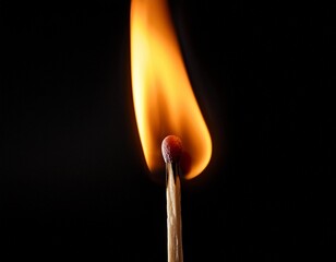 Ein brennendes Streichholz vor schwarzem Hintergrund