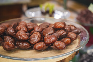 A tray of delicious marron glacés, each delicately glazed chestnut offers a luxurious blend of sweet indulgence and seasonal elegance.