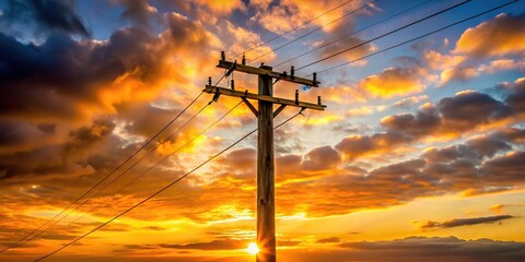Reflection of wooden electricity distribution pole and cables against sunset backdrop in the UK