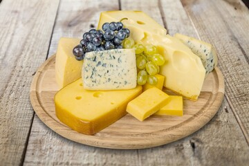 Board with tasty fresh cheese on desk background