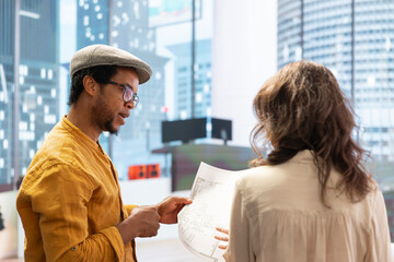 Fototapeta premium Client sharing her office space layout vision with real estate agent, planning to sign a leasing contract for the high class property. Realtor showing the design during a office tour.