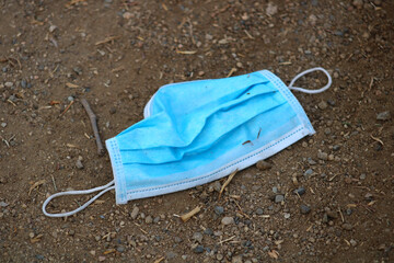 medical mask for illness hanging from tree branch in dirt