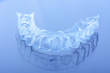 Transparent plastic mouth guard for teeth clenching. Grinding dental bite sleep aid. Dental care.
