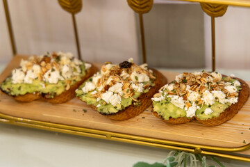 Toasts of dark bread with avocado slices, red tomatoes