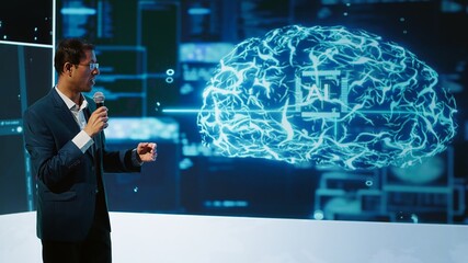 Tech company CEO using summit as platform to launch latest AI products. Manager uses mic to talk at forum to connect with business leaders and investors interested in artificial intelligence, camera A