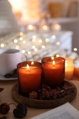 Burning candles and decor on tray indoors. Autumn atmosphere