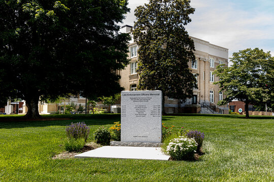 Dobson, NC, USA-June 1, 2024: The Surry County Courthouse was built in 1916 in Classical Revival style.  In the front stands a monument memorial to Lawy Enforcement Officers who died in service.