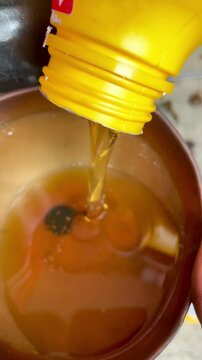 pour the oil liquid into the funnel using a yellow plastic bottle
